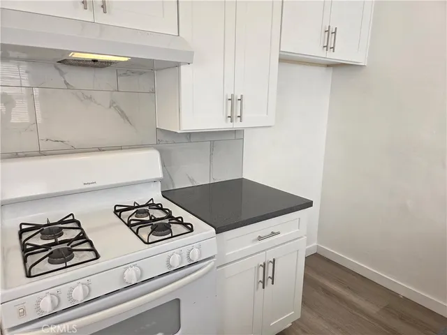 a white stove top oven sitting inside of a kitchen
