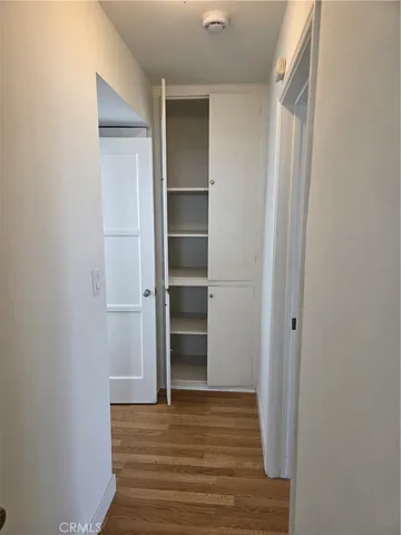 a view of walk in closet with wooden floor