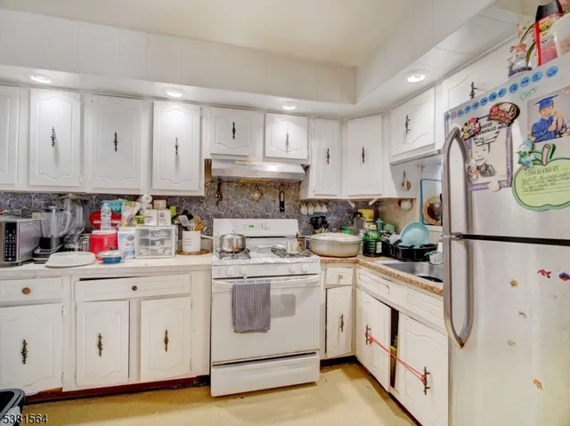 a kitchen with white cabinets and white appliances