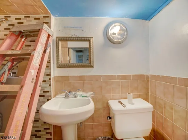 a bathroom with a toilet sink and mirror