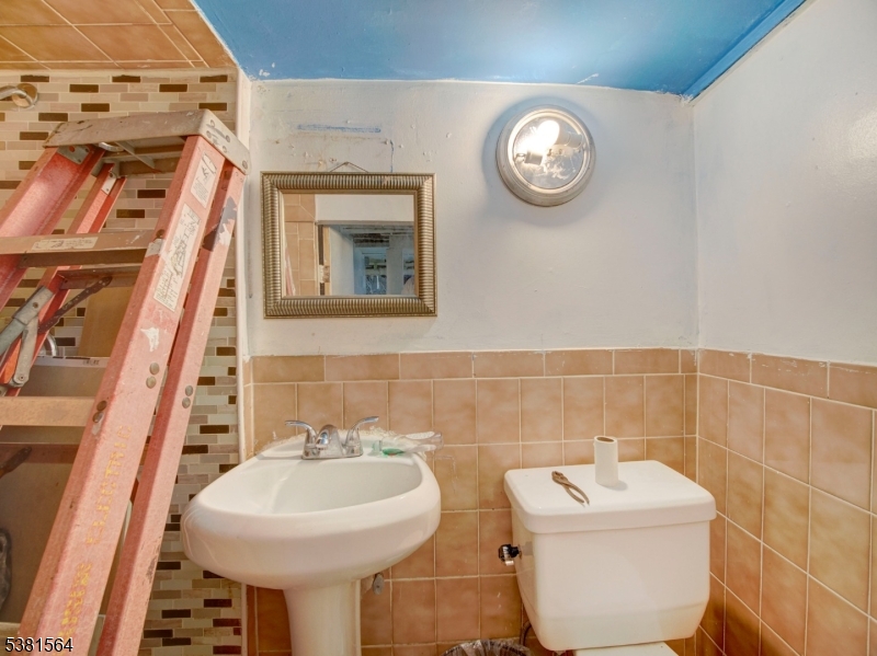 411 Monastery Place Union City, NJ 07087 - Photo 18 of 20 a bathroom with a toilet sink and mirror