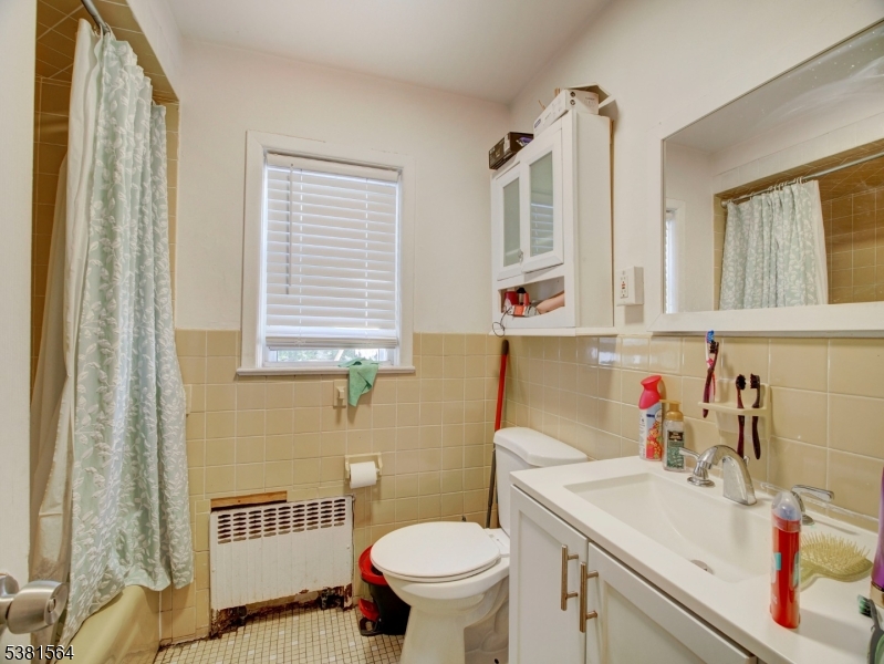 411 Monastery Place Union City, NJ 07087 - Photo 5 of 20 a bathroom with a sink a toilet and a mirror