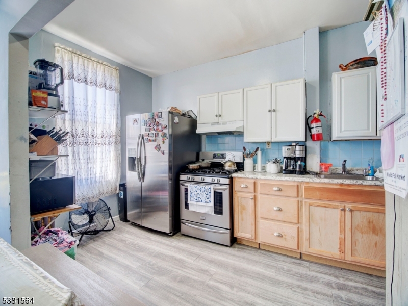 411 Monastery Place Union City, NJ 07087 - Photo 9 of 20 a kitchen with stainless steel appliances granite countertop a refrigerator sink and cabinets