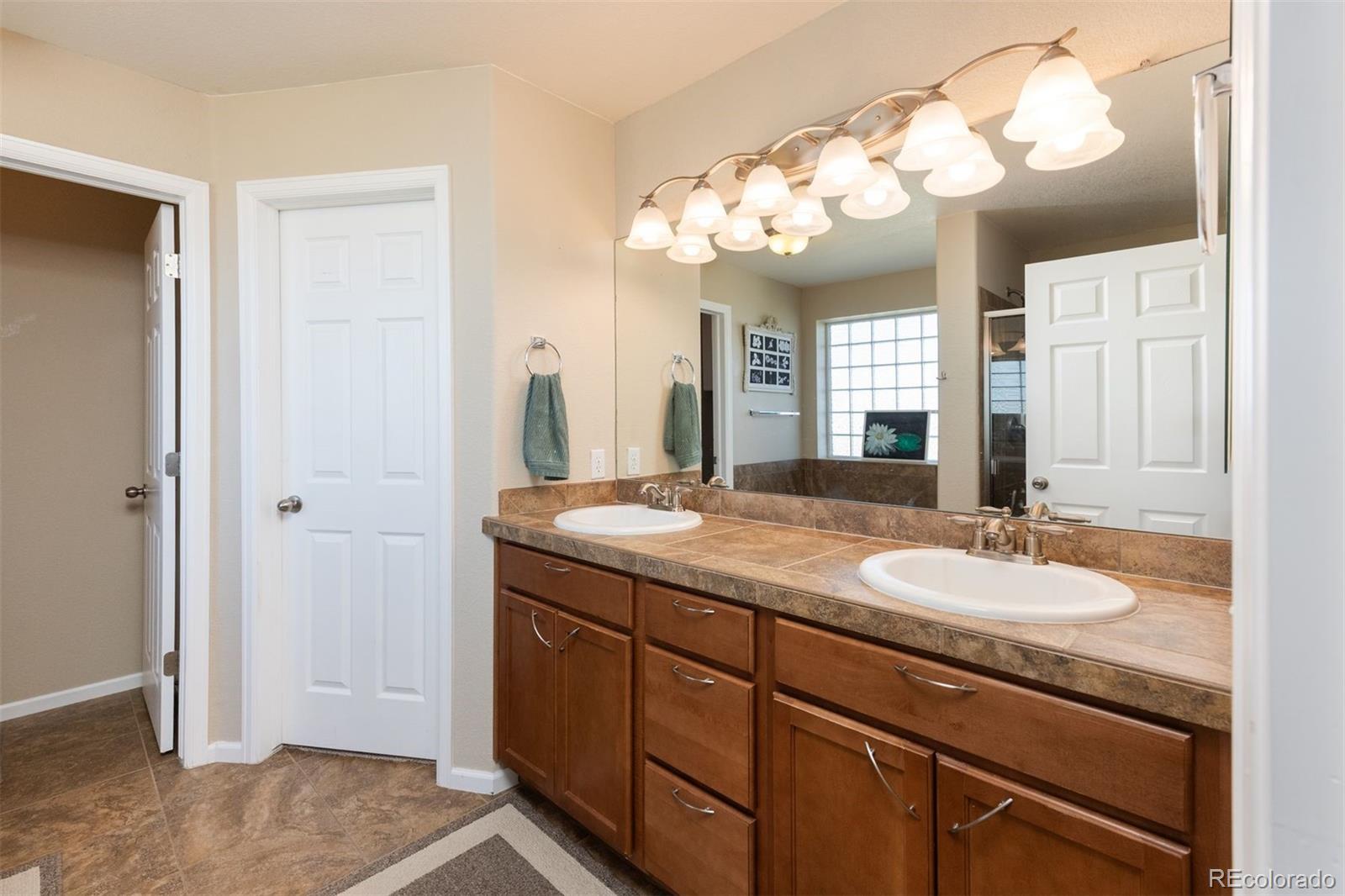 3661 South Perth Circle, Unit 6101 Aurora, CO 80013 - Photo 29 of 48 a bathroom with a granite countertop sink a mirror and a shower