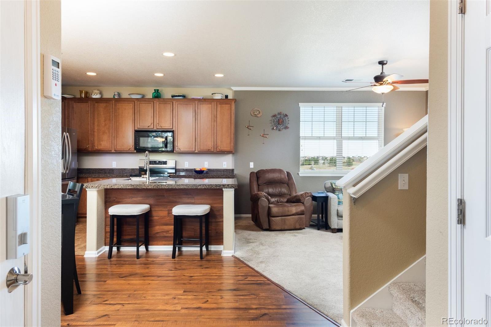 3661 South Perth Circle, Unit 6101 Aurora, CO 80013 - Photo 8 of 48 a kitchen with granite countertop a stove a sink and a refrigerator