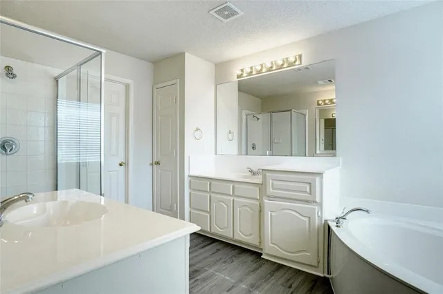 a spacious bathroom with a bathtub and a sink