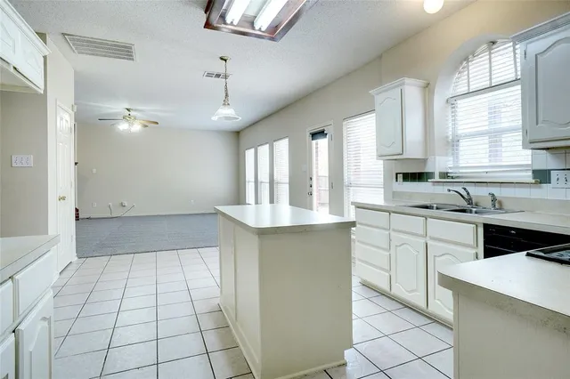 a large kitchen with granite countertop a stove a sink dishwasher and a refrigerator