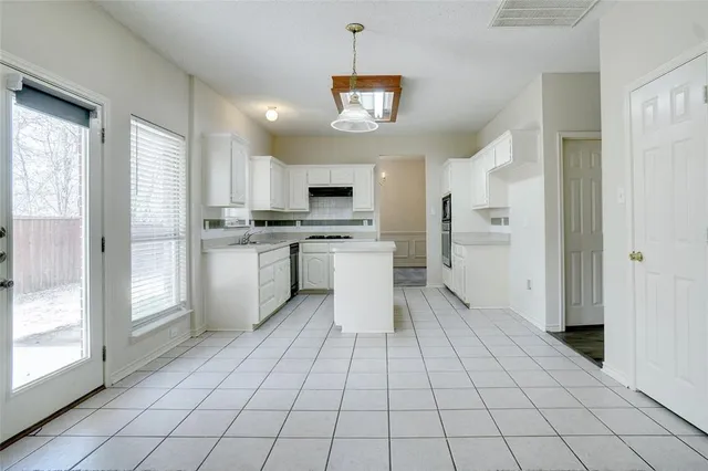 a view of an empty room with a fireplace and a window