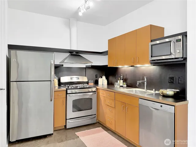 a kitchen with stainless steel appliances granite countertop a stove a sink and a refrigerator