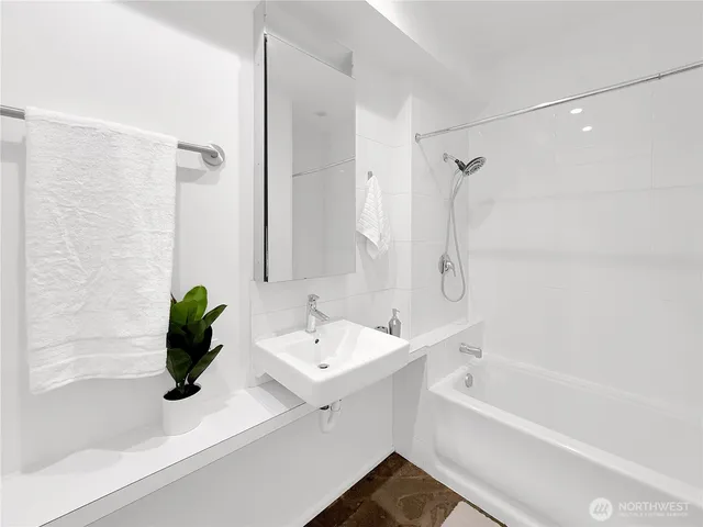 a bedroom with a bed and painting on the wall