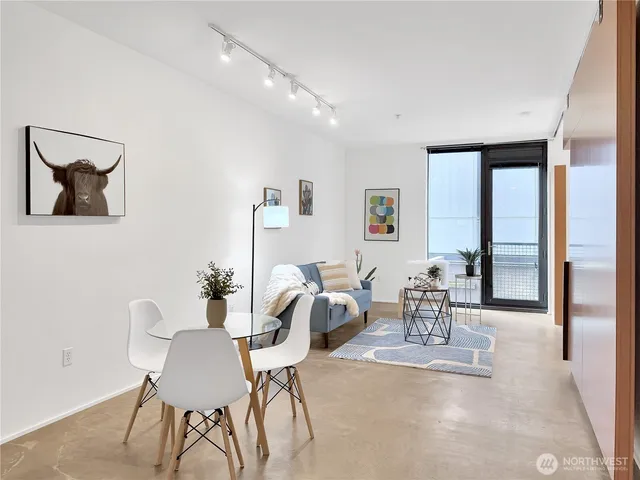 a dining room with furniture and a floor to ceiling window