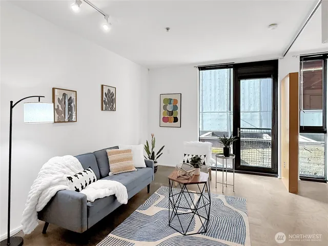 a living room with furniture and a floor to ceiling window