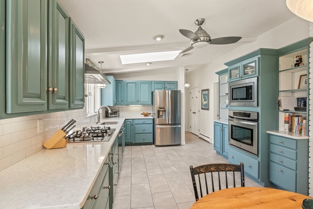 81 Crawford Road Barnstable, MA 02635 - Photo 18 of 42 a kitchen with stainless steel appliances kitchen island granite countertop a refrigerator a stove a sink dishwasher a dining table and chairs with wooden floor