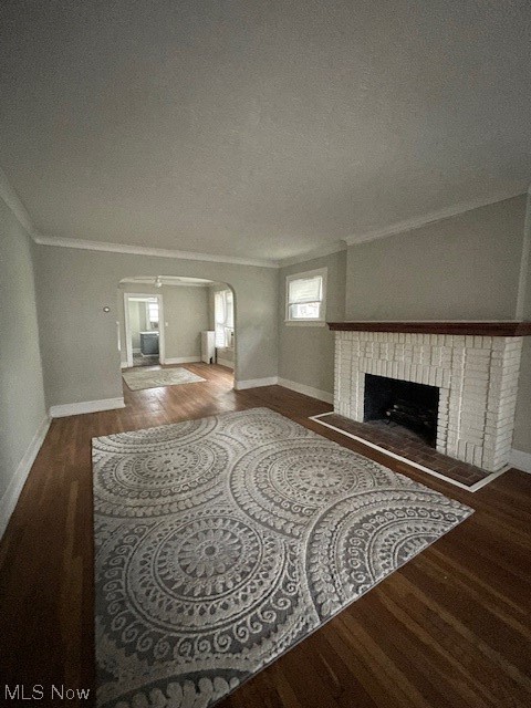 13041 Cedar Road Cleveland, OH 44118 - Photo 4 of 14 Living room with dark hardwood / wood-style flooring, ornamental molding, a textured ceiling, and a brick fireplace