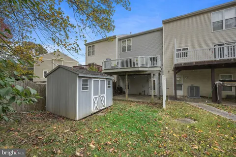 a view of a house with a small yard and wooden fence
