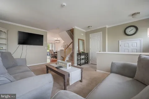 a living room with furniture a flat screen tv and a window