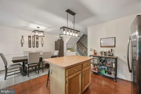 a kitchen that has a lot of cabinets a sink and a wooden floor
