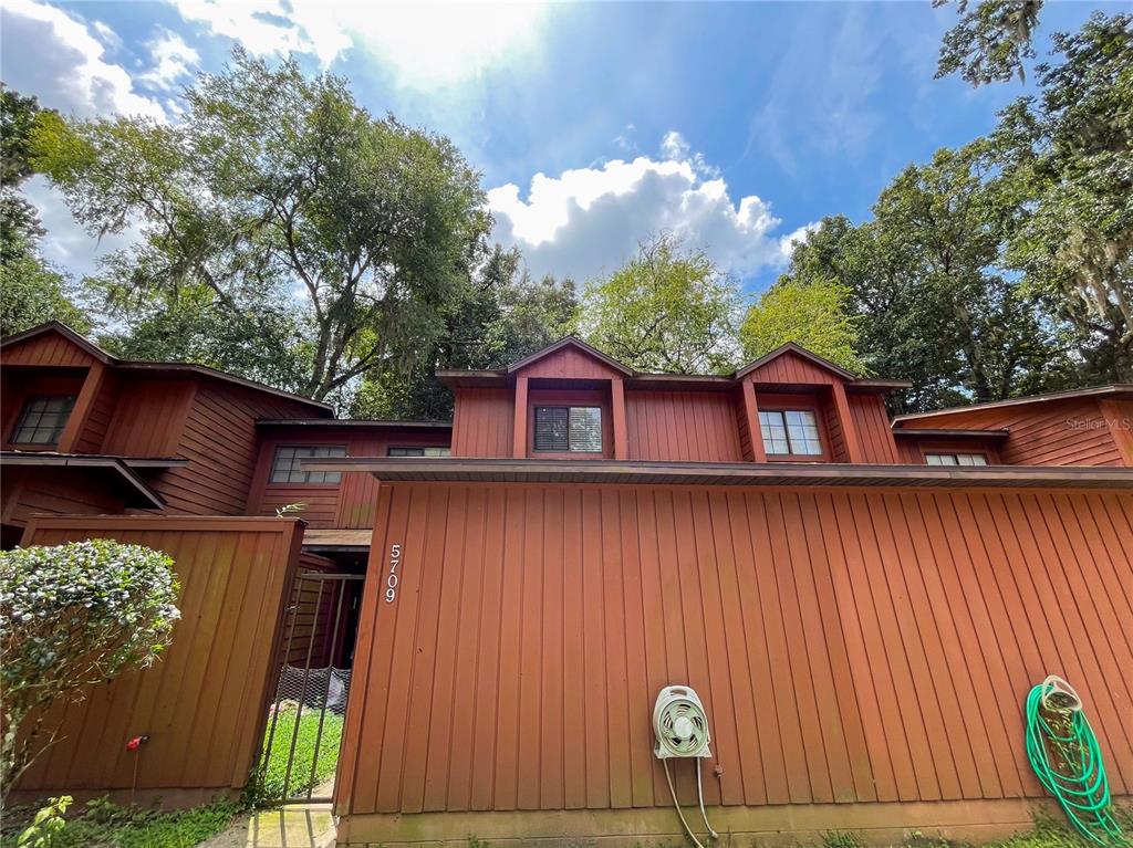 5709 Southwest 10th Place Gainesville, FL 32607 - Photo 1 of 1 a view of a house with a door and wooden fence