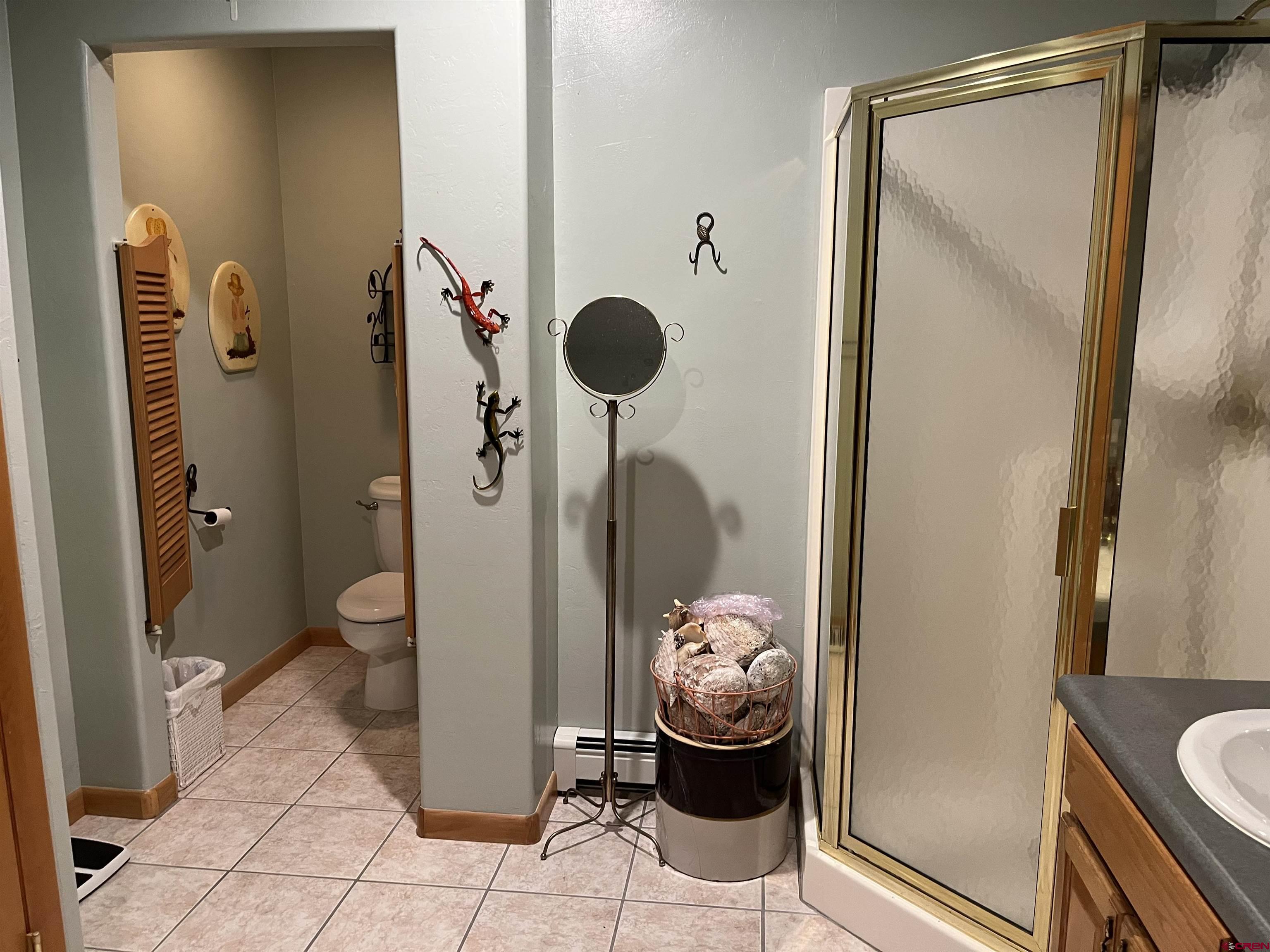 487 1775th Court Delta, CO 81416 - Photo 19 of 35 a bathroom with a granite countertop toilet and a shower