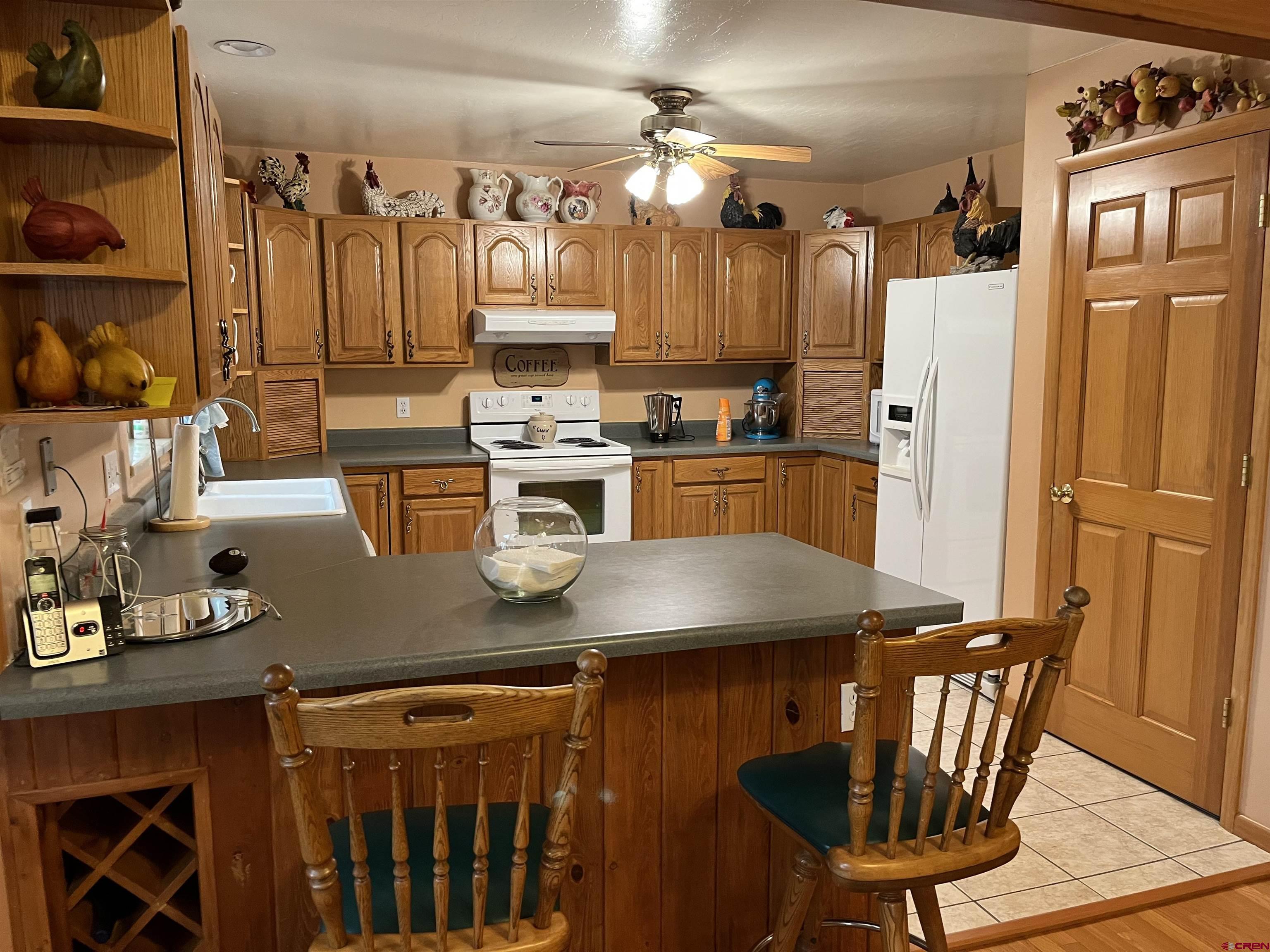 487 1775th Court Delta, CO 81416 - Photo 7 of 35 a kitchen with stainless steel appliances granite countertop a stove a refrigerator a sink a dining table and chairs with wooden floor