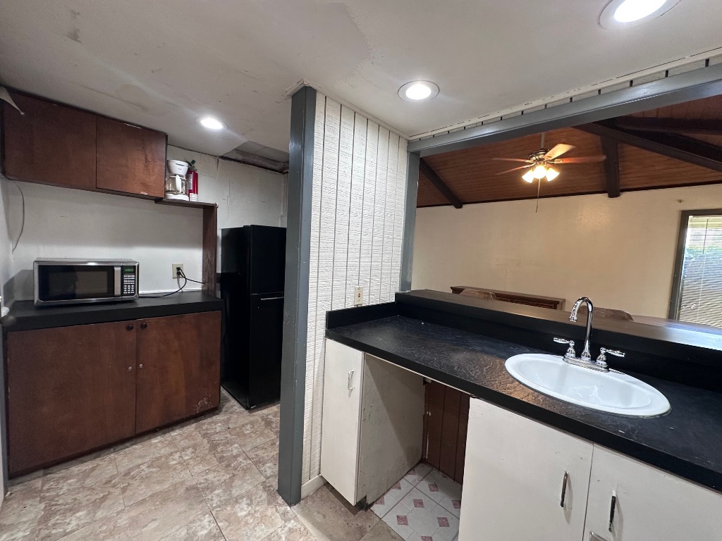 126 Conference Drive, Unit 212 Bastrop, TX 78602 - Photo 7 of 9 a kitchen with a sink refrigerator and microwave