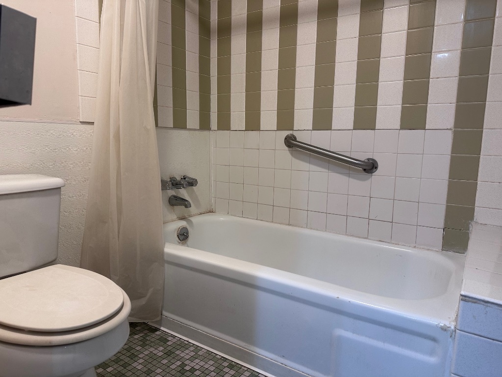 126 Conference Drive, Unit 212 Bastrop, TX 78602 - Photo 9 of 9 a bathroom with a toilet and a bathtub