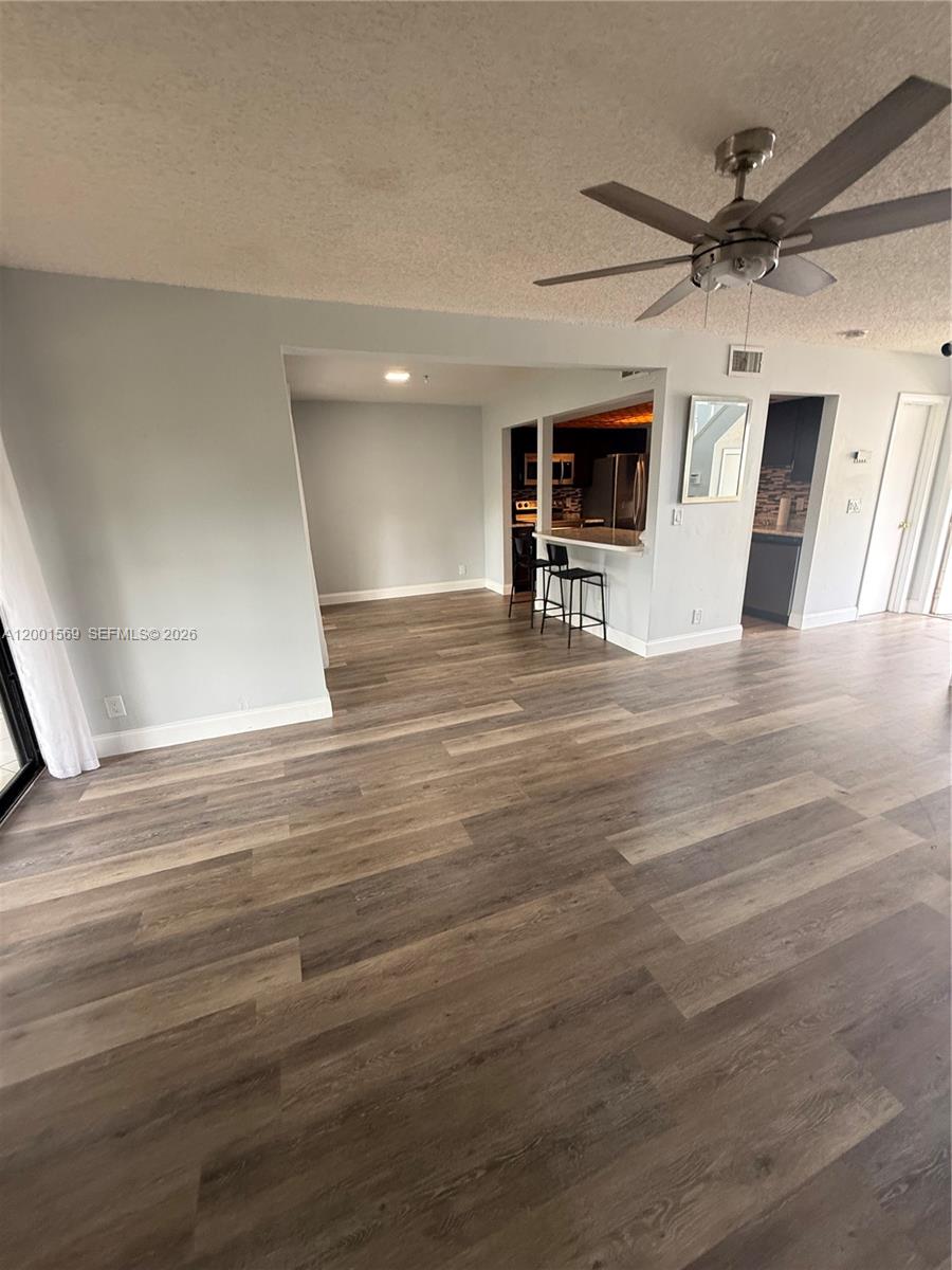 7200 Northwest 2nd Avenue, Unit 160 Boca Raton, FL 33487 - Photo 32 of 40 a view of a livingroom with a stove wooden floor and a ceiling fan