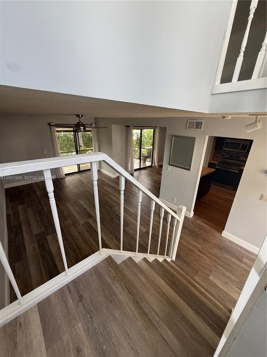 7200 Northwest 2nd Avenue, Unit 160 Boca Raton, FL 33487 - Photo 34 of 40 a view of an empty room with wooden floor and stairs