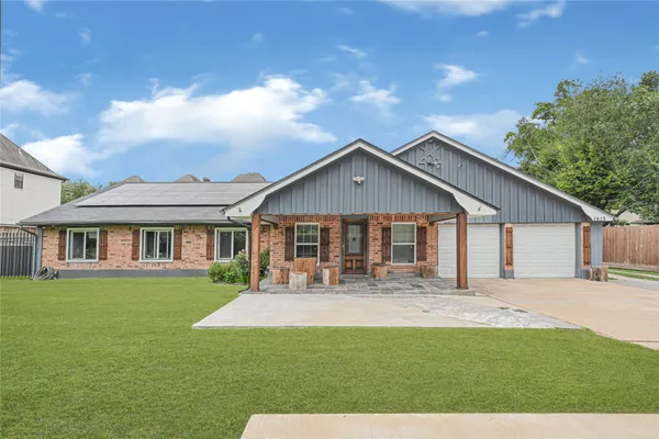 a front view of a house with a yard and trees