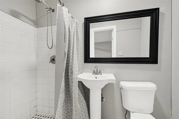 a bathroom with a toilet sink vanity and mirror