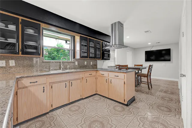 a kitchen with white cabinets and window