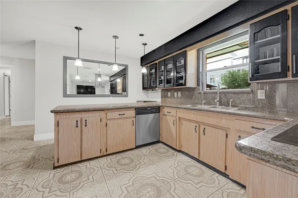 a kitchen with stainless steel appliances granite countertop a refrigerator a sink and white cabinets