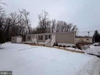 a front view of house with yard and trees in the background