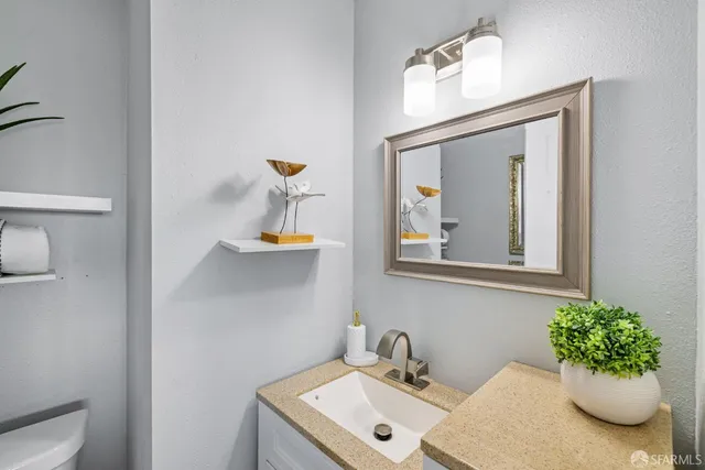 a living room with furniture a mirror and a wooden floor