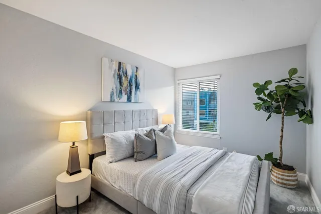 a bedroom with a bed and a lamp on the dresser