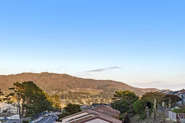 an aerial view of residential houses with outdoor space and parking