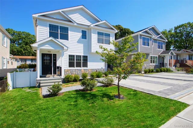 a front view of a house with a yard and green space