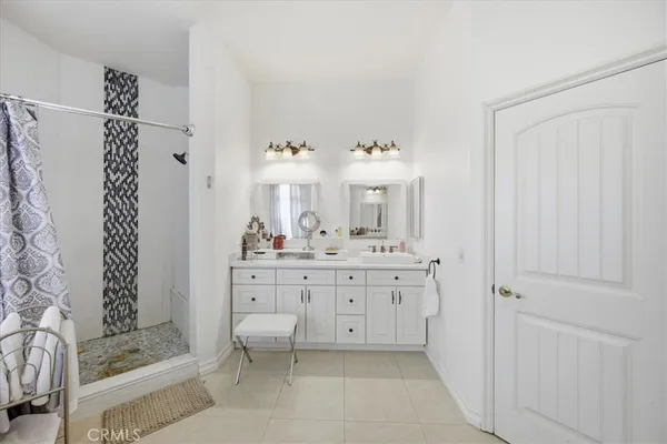 a en suite bathroom with a granite countertop sink and a mirror
