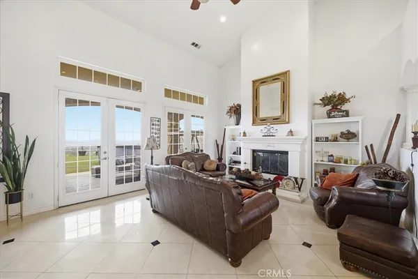 a living room with furniture a fireplace and a floor to ceiling window