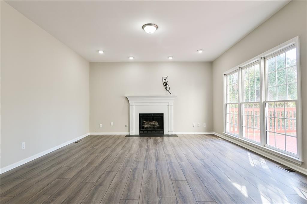 2670 Factor Walk Boulevard Suwanee, GA 30024 - Photo 11 of 57 wooden floor fireplace and windows in an empty room
