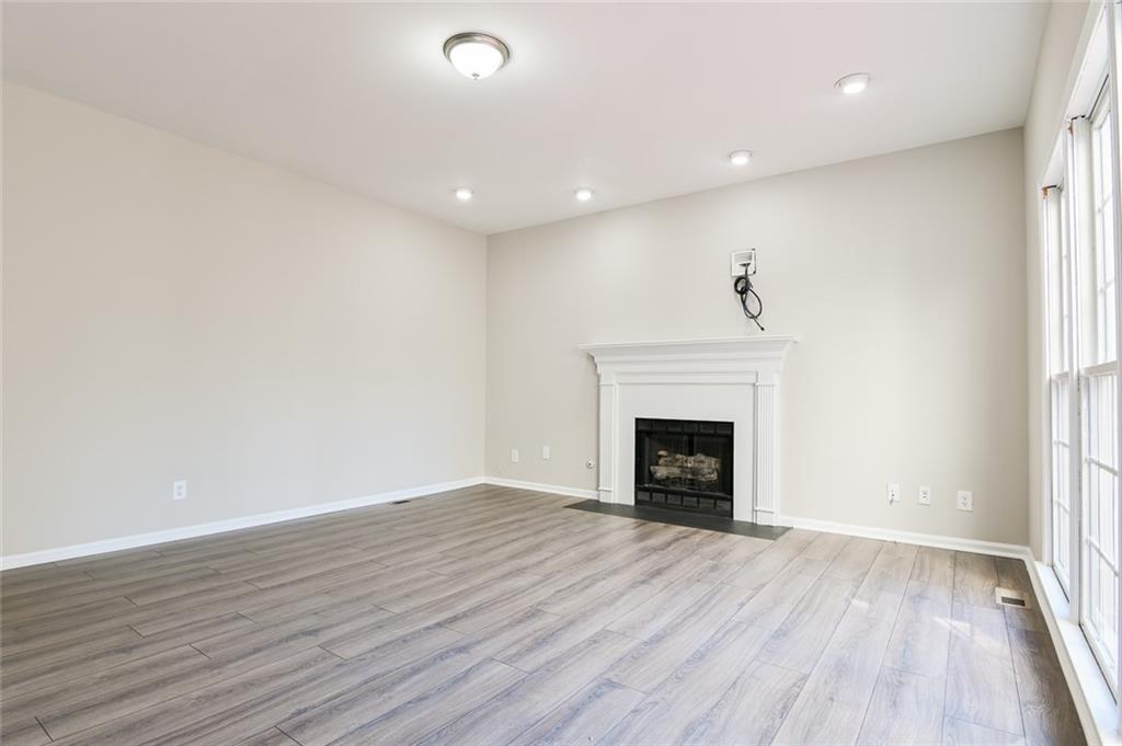 2670 Factor Walk Boulevard Suwanee, GA 30024 - Photo 13 of 57 an empty room with wooden floor fireplace and windows