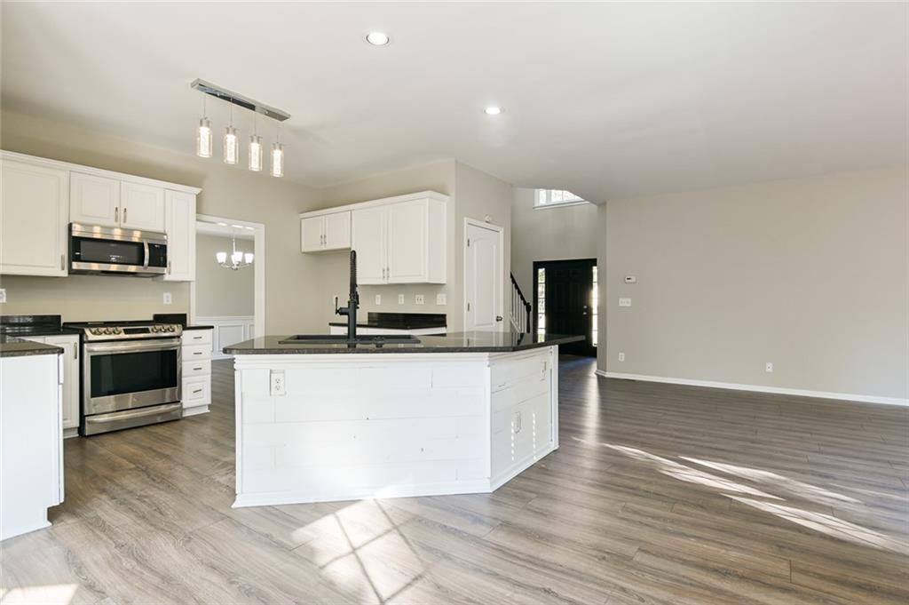 2670 Factor Walk Boulevard Suwanee, GA 30024 - Photo 6 of 57 a large kitchen with stainless steel appliances granite countertop a stove a sink and a microwave