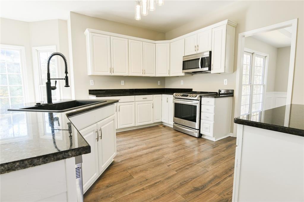 2670 Factor Walk Boulevard Suwanee, GA 30024 - Photo 7 of 57 a kitchen with granite countertop a stove top oven sink and cabinets