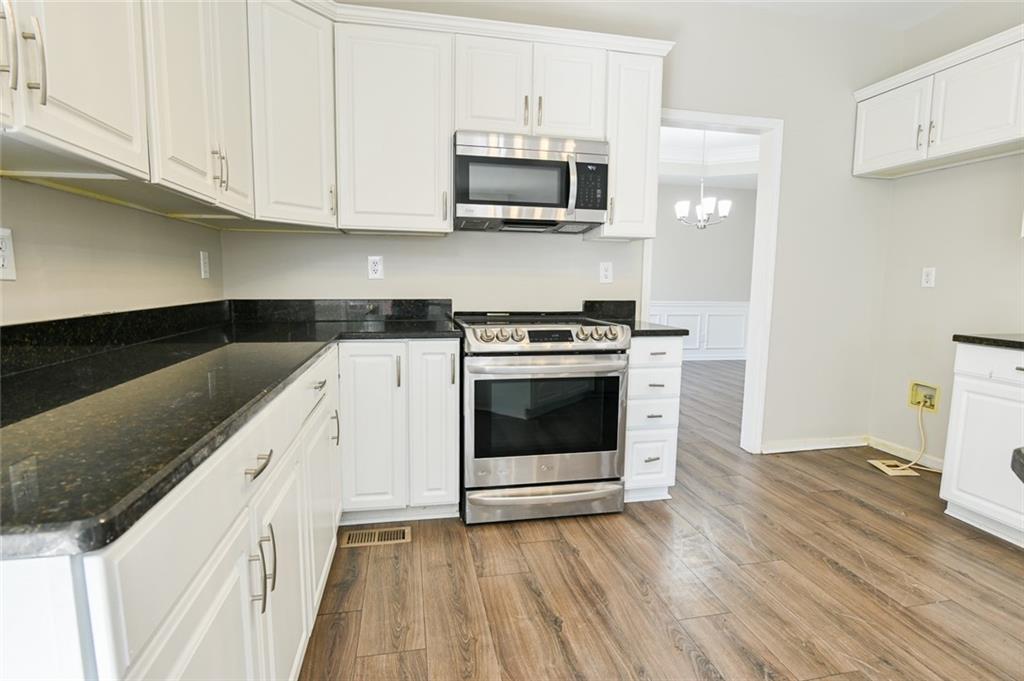2670 Factor Walk Boulevard Suwanee, GA 30024 - Photo 9 of 57 a kitchen with stainless steel appliances granite countertop a stove a microwave and a white cabinets