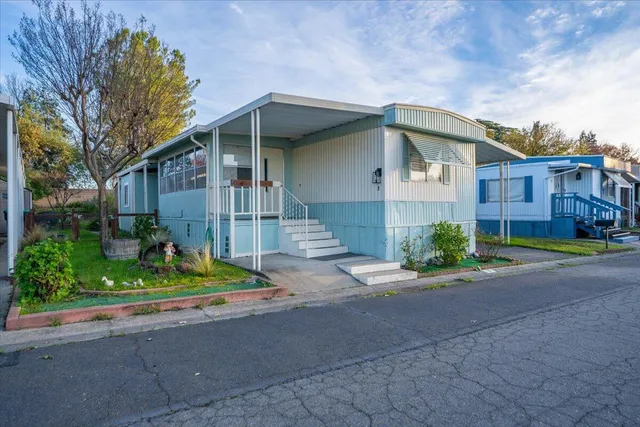 a front view of a house with a yard and potted plants