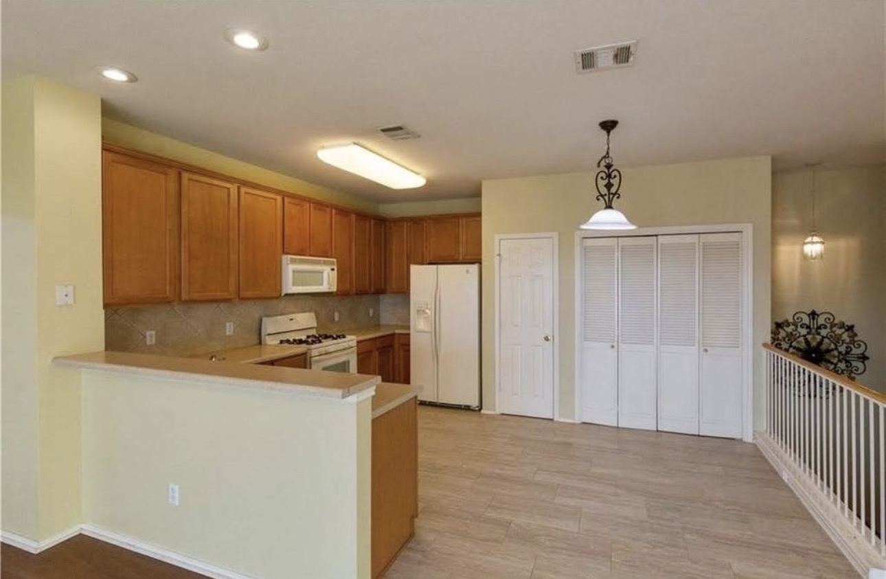 1900 Scofield Ridge Parkway, Unit 3101 Austin, TX 78727 - Photo 6 of 24 Open-concept kitchen and living area featuring wood cabinetry, white appliances, a tile backsplash, and wood-finish flooring
