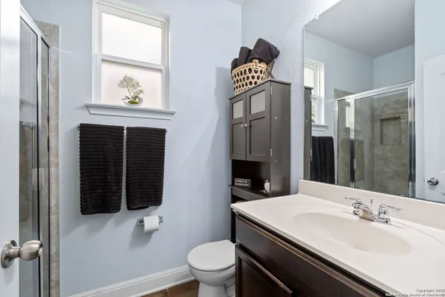 a bathroom with a sink a toilet and shower