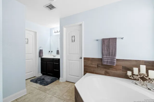 a large bedroom with a bed and a dresser in it