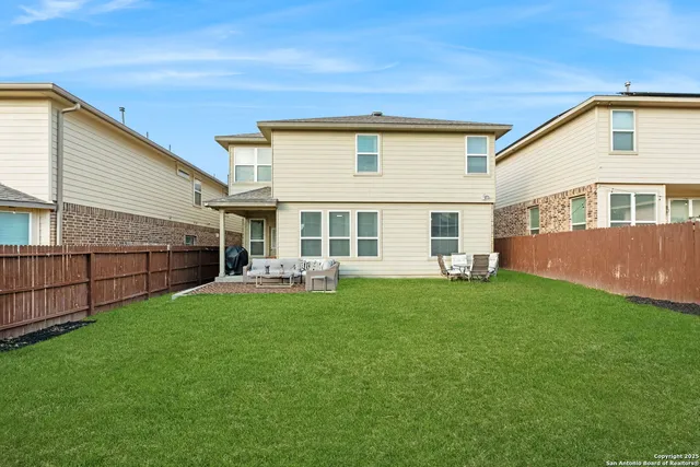 a view of a white house with a yard and potted plants