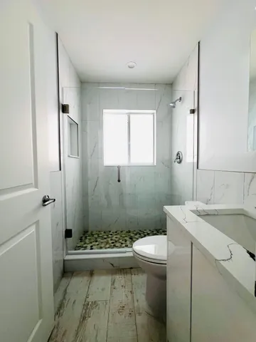 a bathroom with a sink a toilet and shower